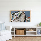 Starry veil woman Frame TV art above a white console with a rattan basket in a coastal living room