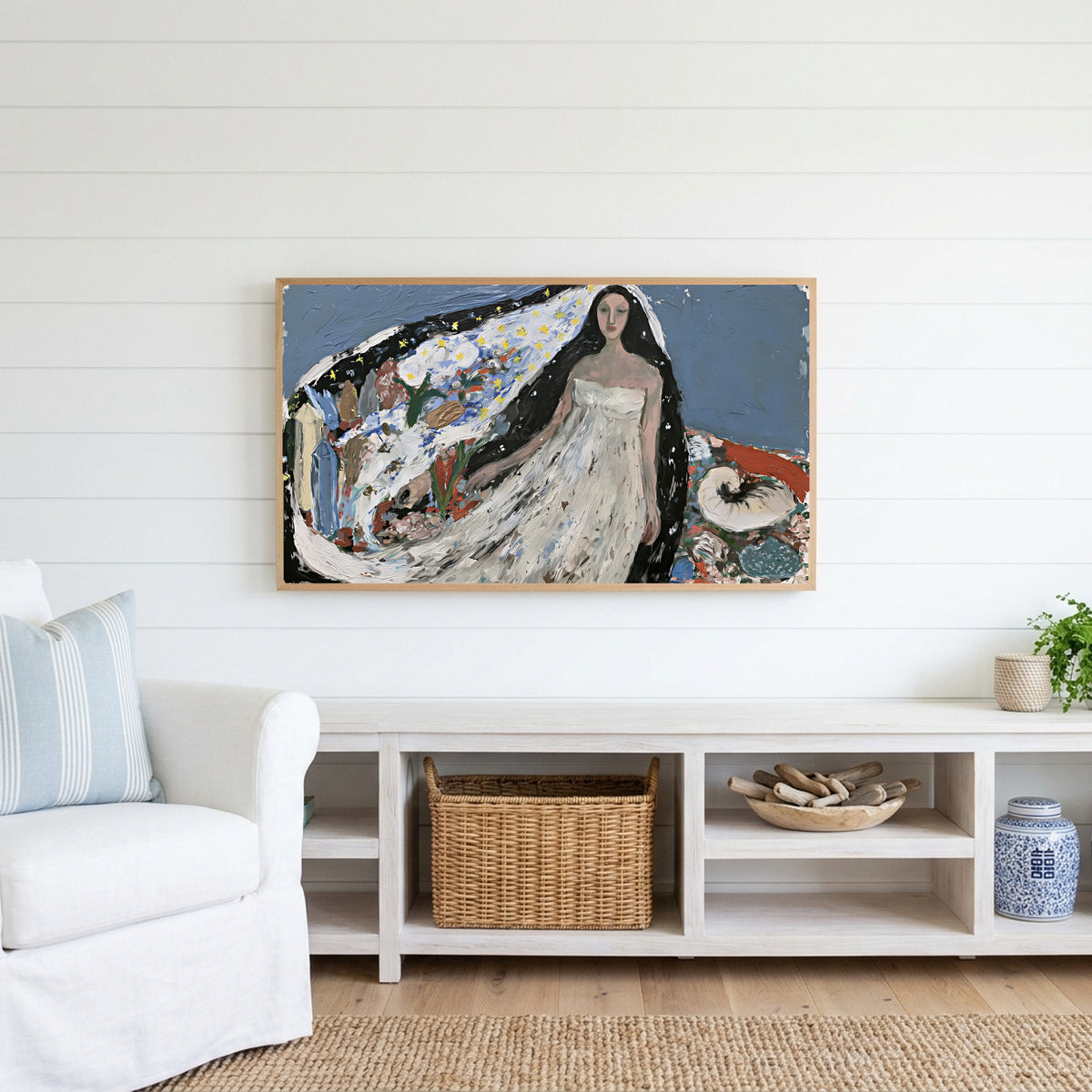 Starry veil woman Frame TV art above a white console with a rattan basket in a coastal living room