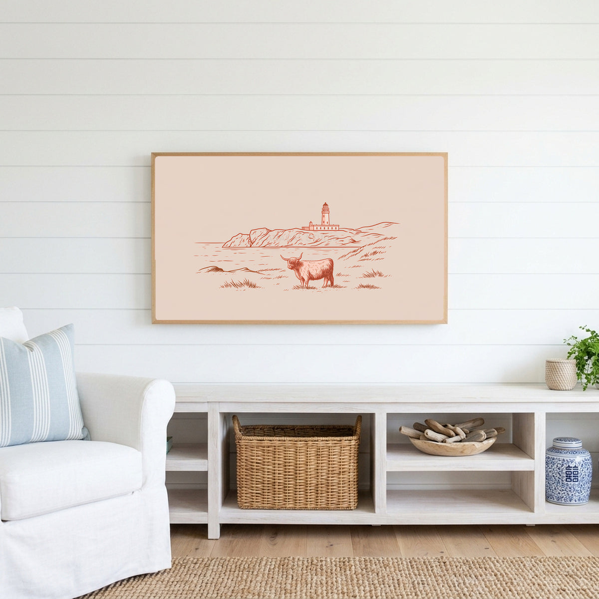 Highland cow lighthouse Frame TV art above a white console with a rattan basket in a coastal living room