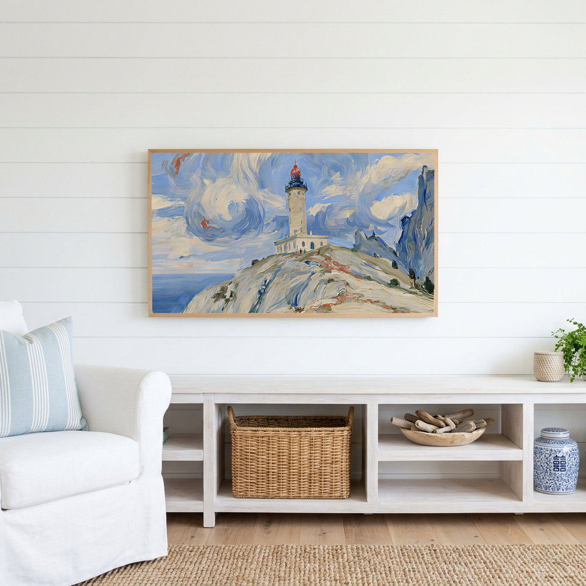 Lighthouse on a cliff Frame TV art above a white console with a rattan basket in a coastal living room