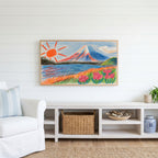 Crayon Mount Fuji Frame TV art above a white console with a rattan basket in a coastal living room