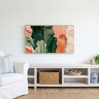Green and copper strokes Frame TV art above a white console with a rattan basket in a coastal living room