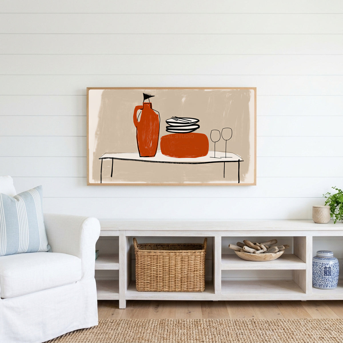 Minimalist table with jug and wine glasses Frame TV art above a white console with a rattan basket in a coastal living room