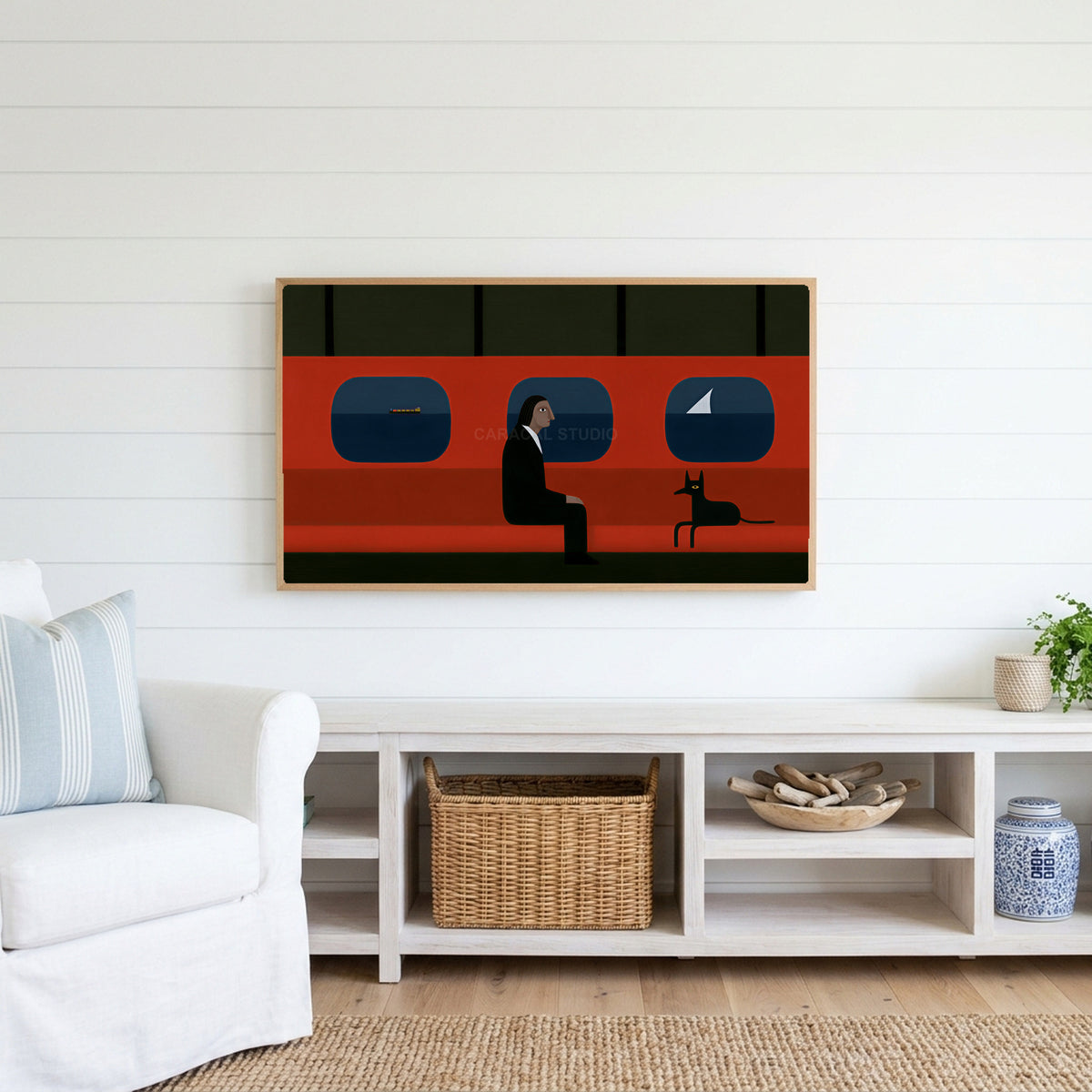 Ferry man and black dog Frame TV art above a white console with a rattan basket in a coastal living room