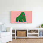 Grumpy gorilla Frame TV art above a white console with a rattan basket in a coastal living room