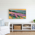 Heather hills Frame TV art above a white console with a rattan basket in a coastal living room