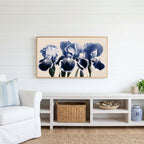 Blue iris Frame TV art above a white console with a rattan basket in a coastal living room