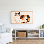 Calico cat Frame TV art above a white console with a rattan basket in a coastal living room