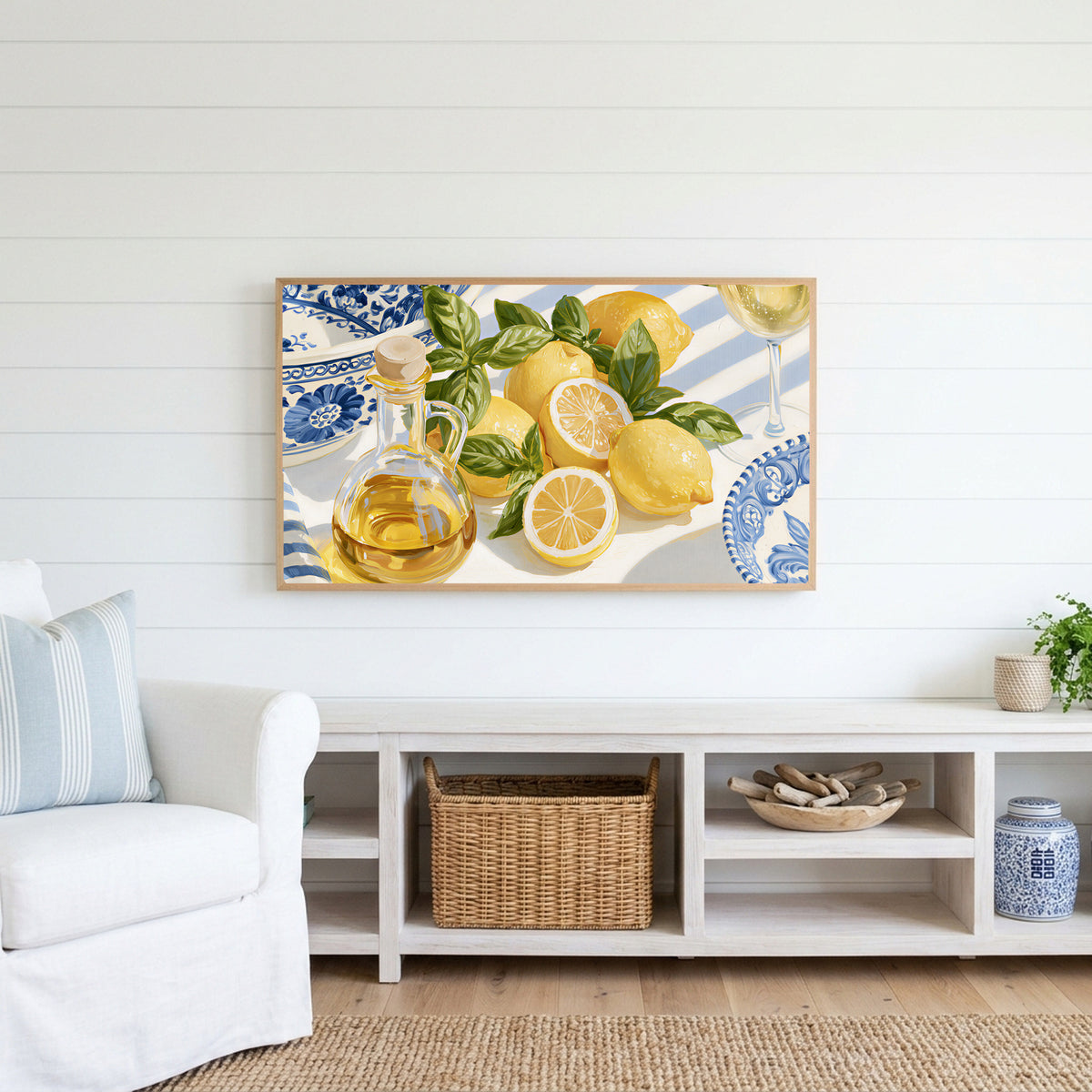 Lemons and olive oil Frame TV art above a white console with a rattan basket in a coastal living room