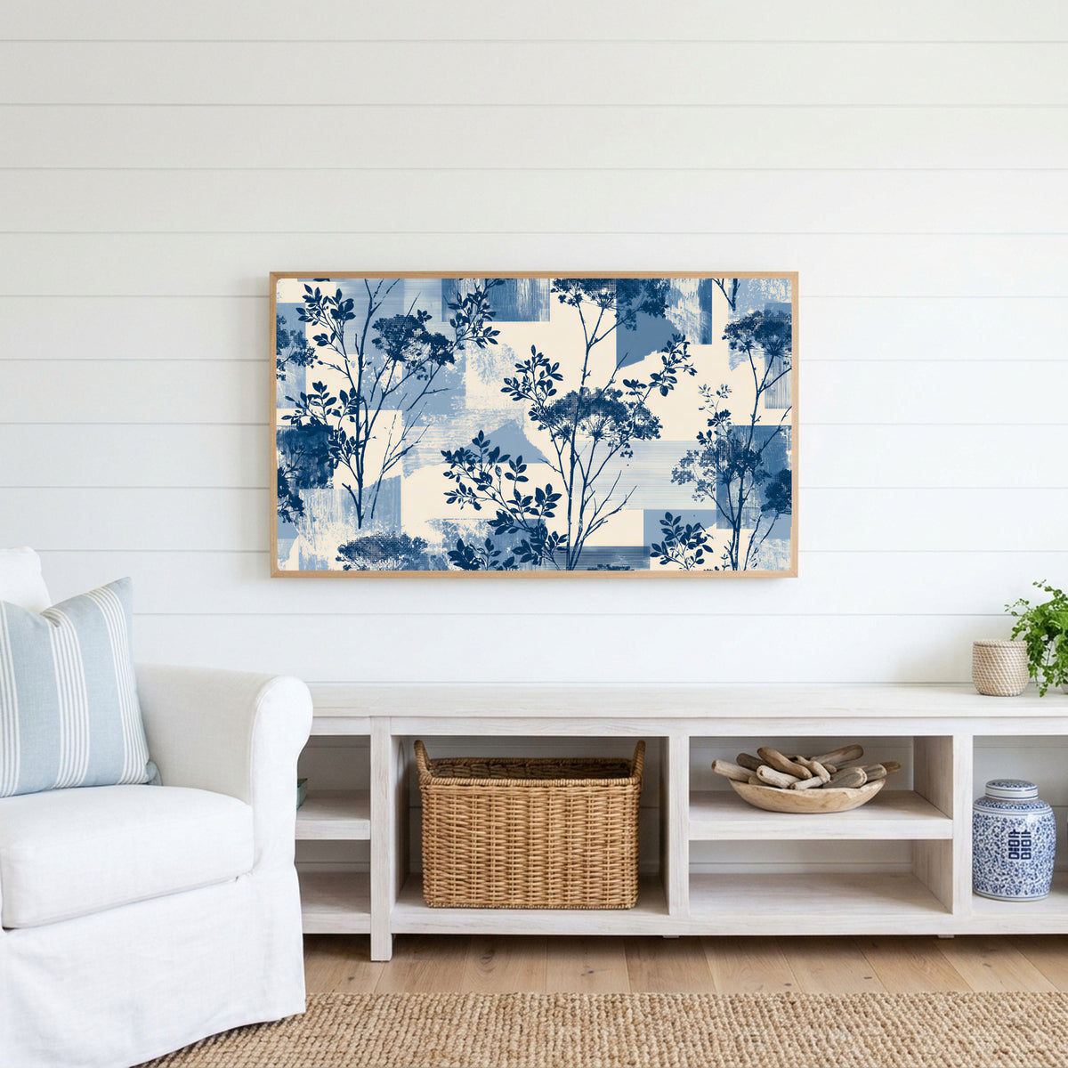 Blue botanical Frame TV art above a white console with a rattan basket in a coastal living room