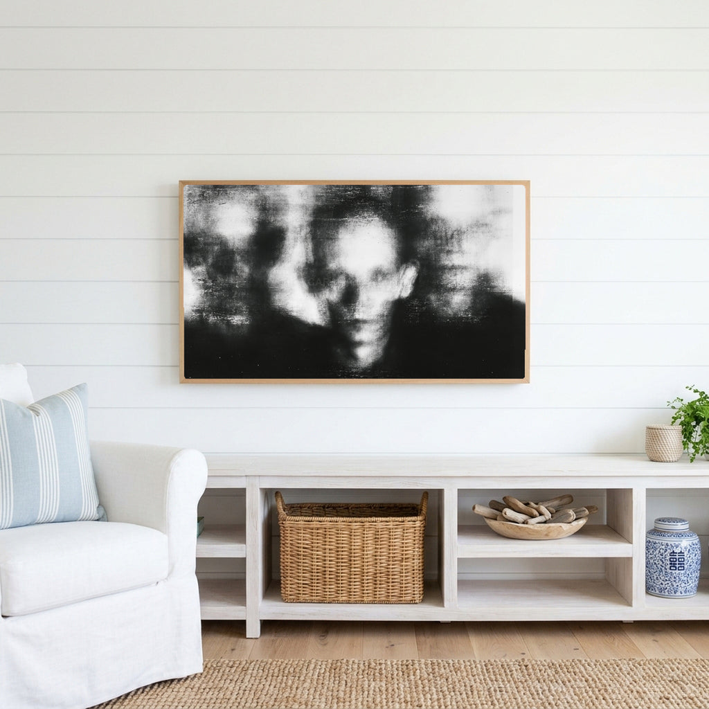 Blurred faces Frame TV art above a white console with a rattan basket in a coastal living room