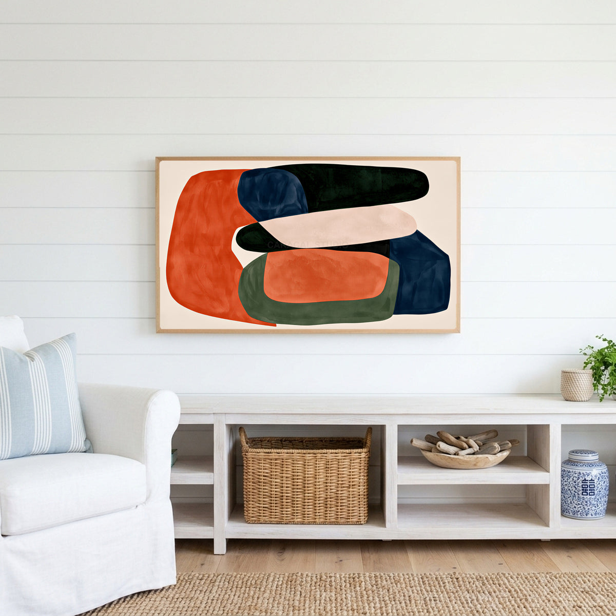 Abstract organic shapes Frame TV art above a white console with a rattan basket in a coastal living room