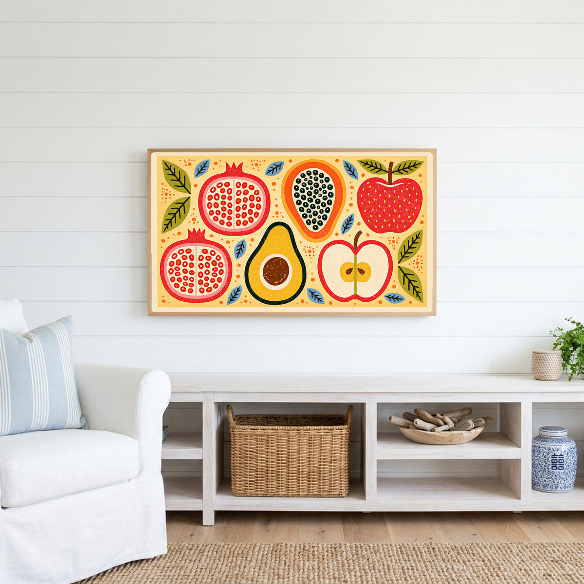 Colorful fruit halves Frame TV art above a white console with a rattan basket in a coastal living room