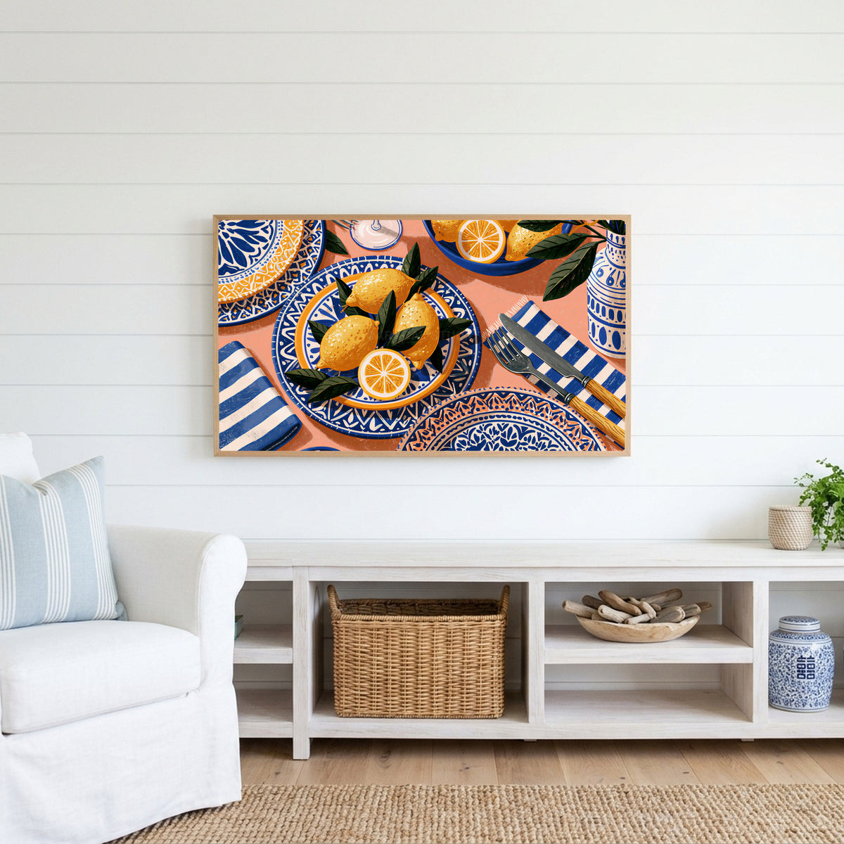 Mediterranean lemons Frame TV art above a white console with a rattan basket in a coastal living room