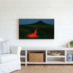 Woman running over green hills Frame TV art above a white console with a rattan basket in a coastal living room