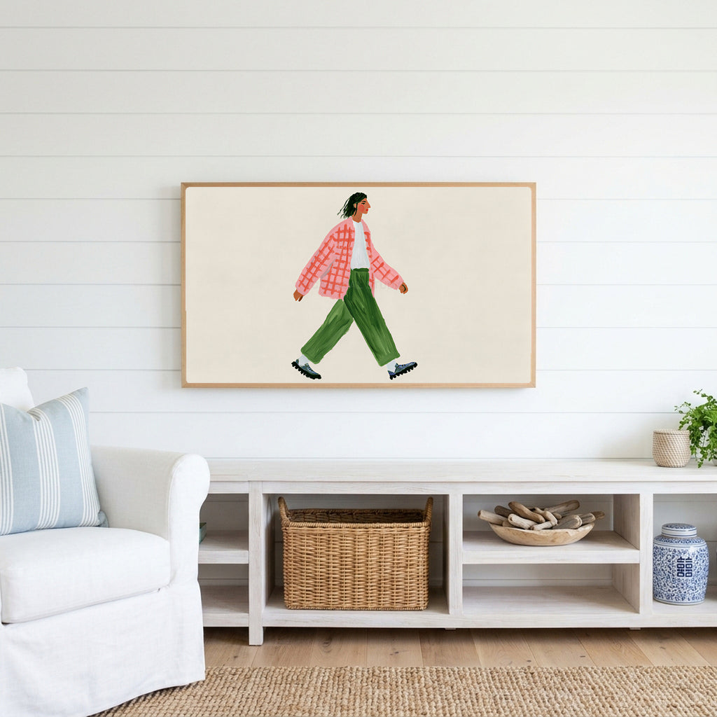 Woman walking Frame TV art above a white console with a rattan basket in a coastal living room