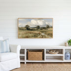 Countryside meadow and cottage Frame TV art above a white console with a rattan basket in a coastal living room