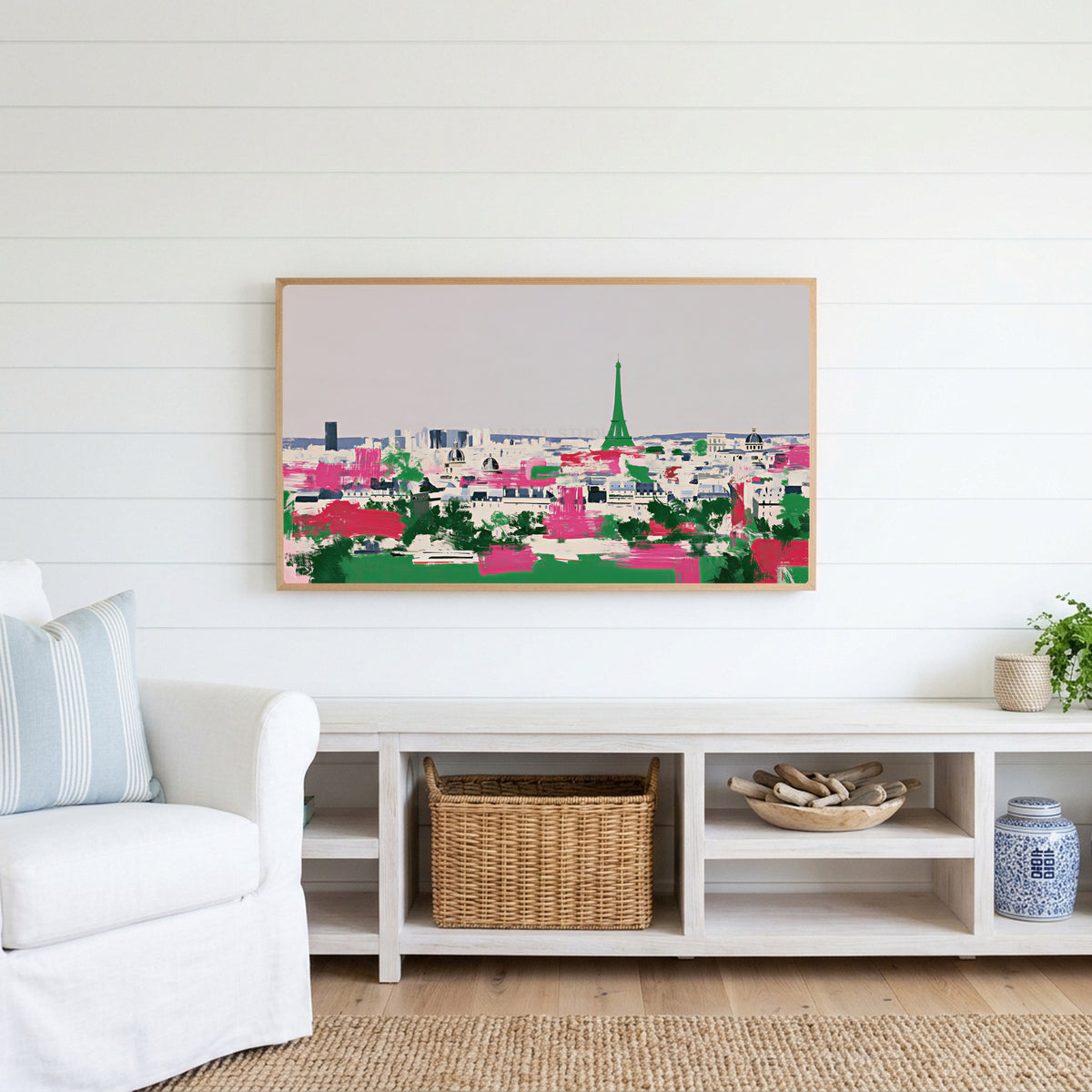 Paris skyline Frame TV art above a white console with a rattan basket in a coastal living room