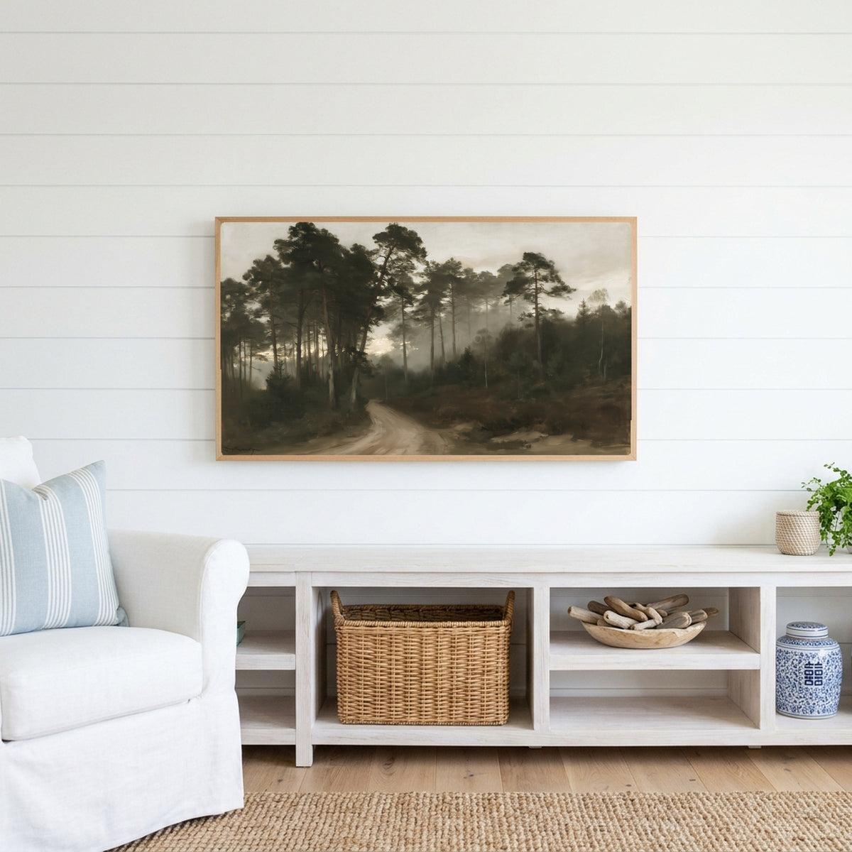 Misty pine forest path Frame TV art above a white console with a rattan basket in a coastal living room