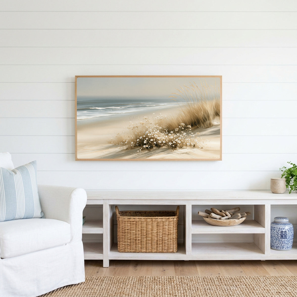 Dune grass and daisies Frame TV art above a white console with a rattan basket in a coastal living room