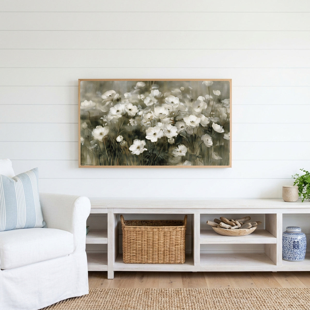 White anemone field Frame TV art above a white console with a rattan basket in a coastal living room