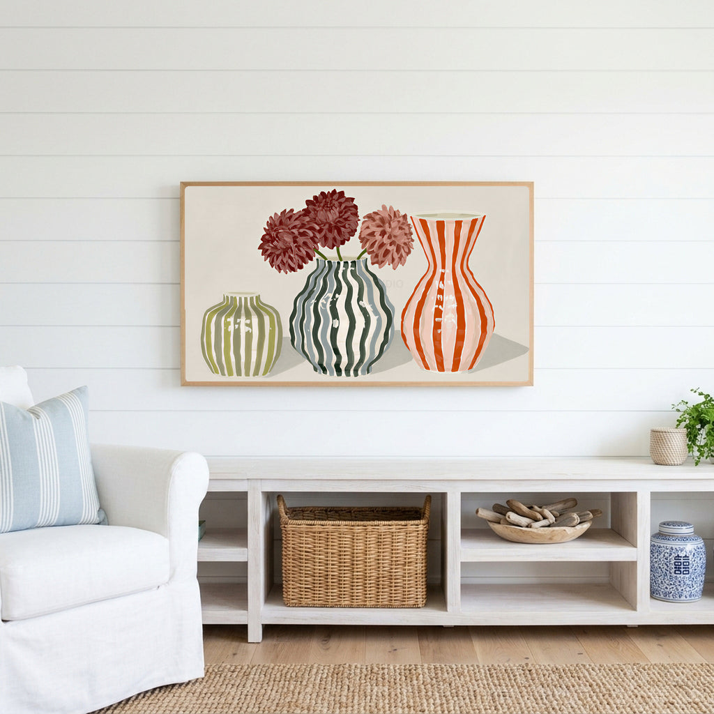 Striped vases Frame TV art above a white console with a rattan basket in a coastal living room