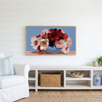 Peony and orchid bouquet Frame TV art above a white console with a rattan basket in a coastal living room