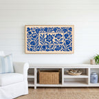 Blue paper cut flowers Frame TV art above a white console with a rattan basket in a coastal living room