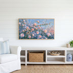 Pink spring flower buds Frame TV art above a white console with a rattan basket in a coastal living room