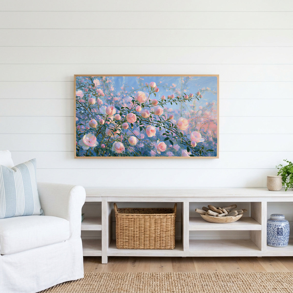 Pink spring flower buds Frame TV art above a white console with a rattan basket in a coastal living room
