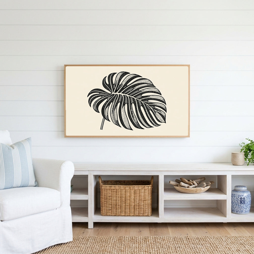 Monstera leaf Frame TV art above a white console with a rattan basket in a coastal living room