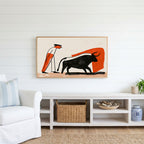 Matador and bull Frame TV art above a white console with a rattan basket in a coastal living room