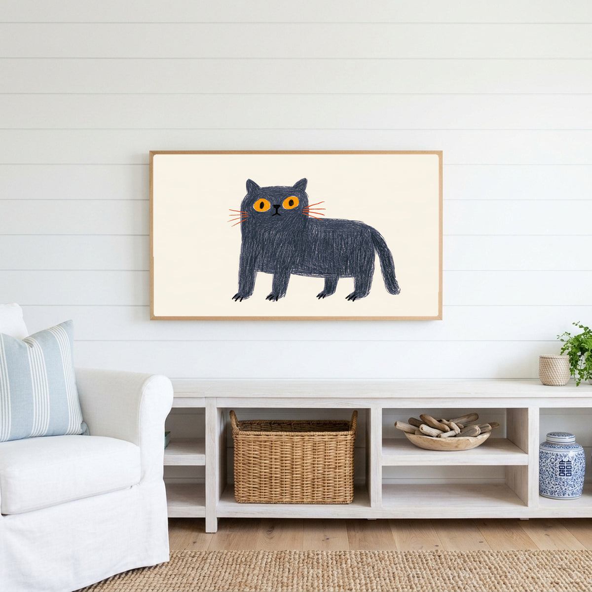 British Blue cat Frame TV art above a white console with a rattan basket in a coastal living room