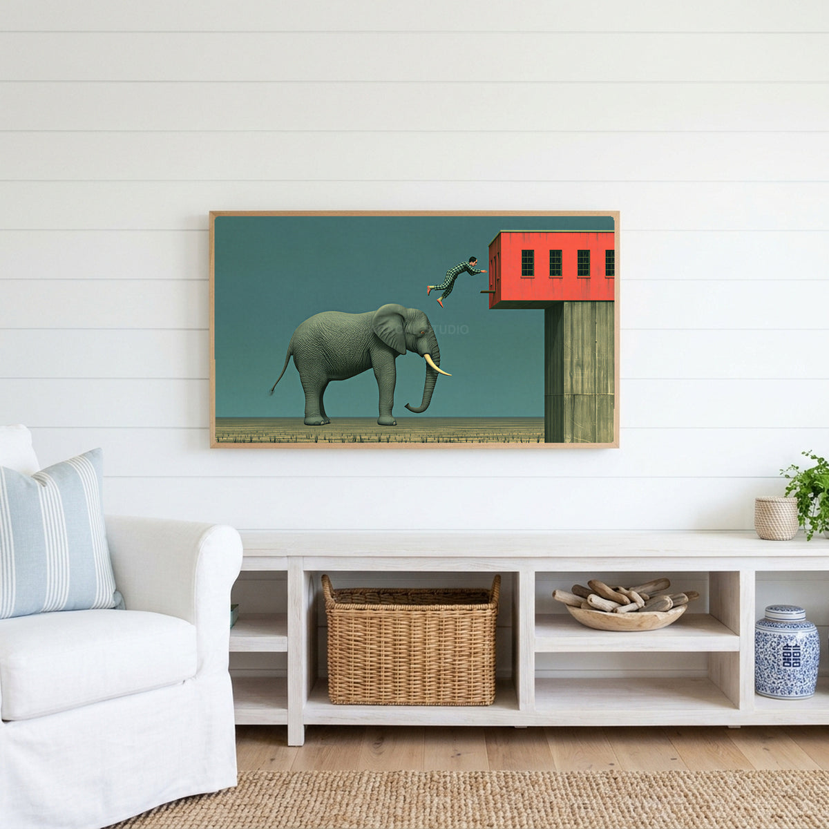 Elephant and leaping man Frame TV art above a white console with a rattan basket in a coastal living room