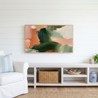 Green and peach abstract Frame TV art above a white console with a rattan basket in a coastal living room