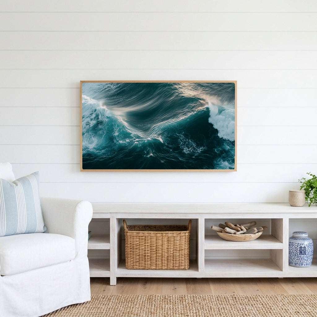 Aerial ocean waves Frame TV art above a white console with a rattan basket in a coastal living room