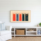 Five tall cats Frame TV art above a white console with a rattan basket in a coastal living room