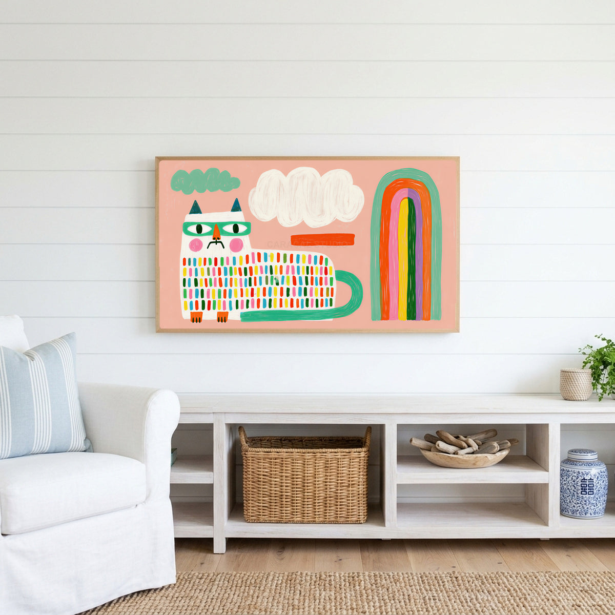 Rainbow cat Frame TV art above a white console with a rattan basket in a coastal living room
