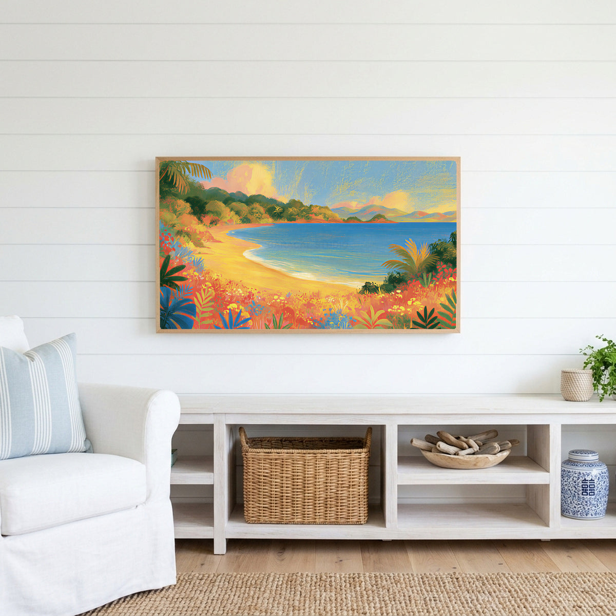 Tropical cove Frame TV art above a white console with a rattan basket in a coastal living room