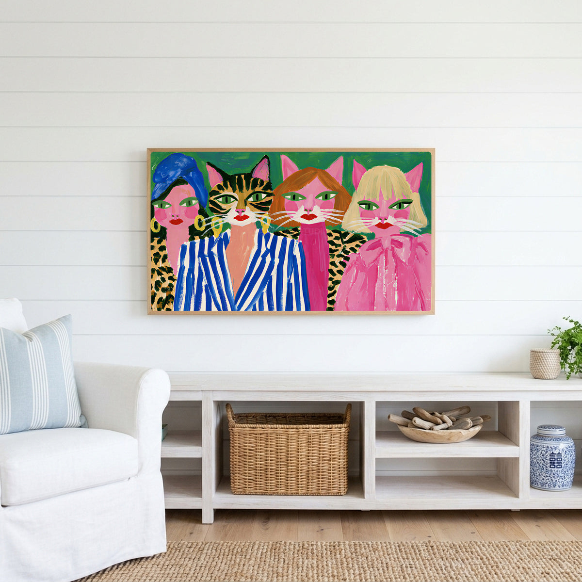 Cat ladies Frame TV art above a white console with a rattan basket in a coastal living room