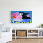 Pop art penguin Frame TV art above a white console with a rattan basket in a coastal living room