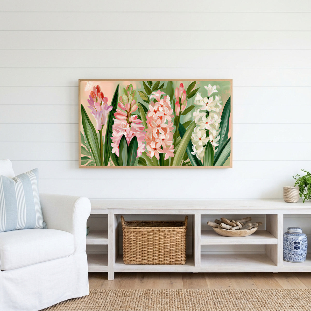 Spring hyacinths Frame TV art above a white console with a rattan basket in a coastal living room