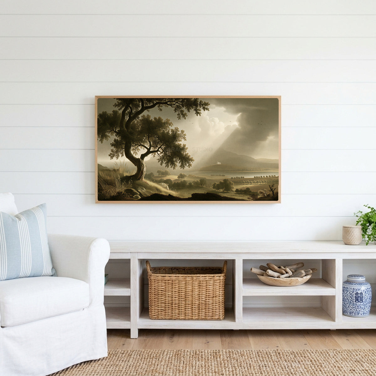 Vintage tree landscape Frame TV art above a white console with a rattan basket in a coastal living room