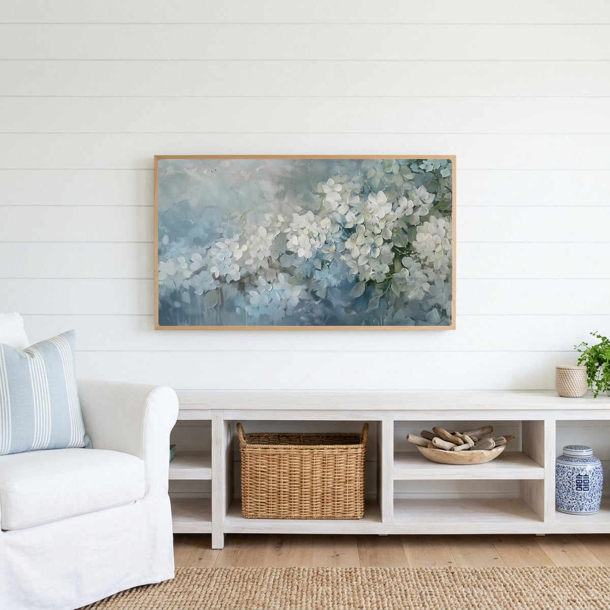 Hydrangea Frame TV art above a white console with a rattan basket in a coastal living room