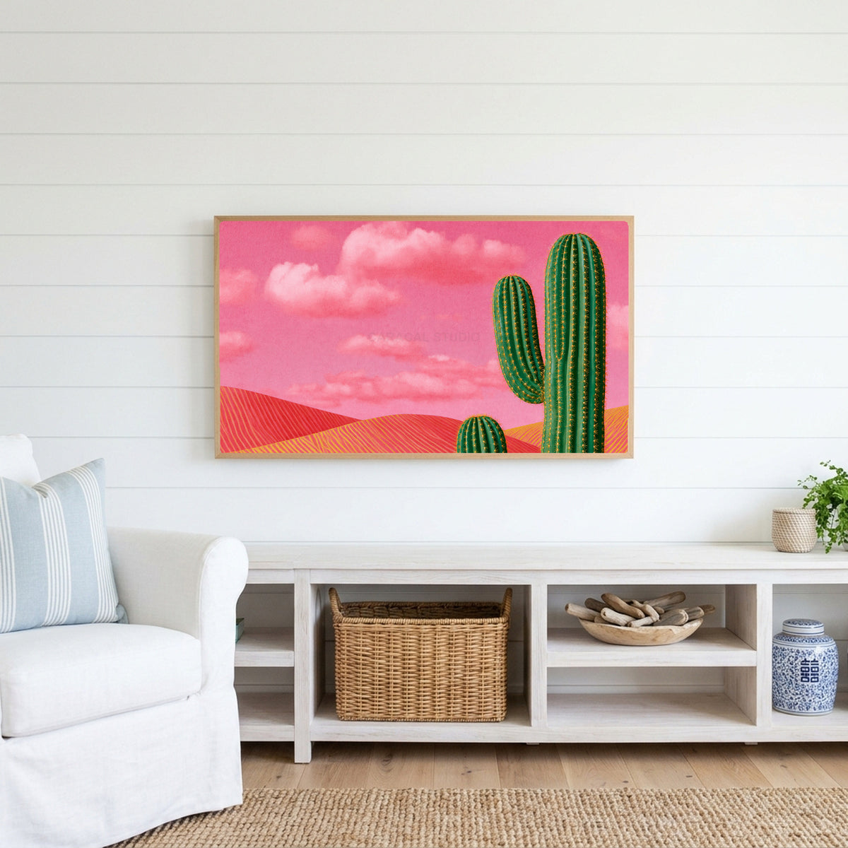 Saguaro cactus Frame TV art above a white console with a rattan basket in a coastal living room