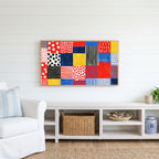 Polka dot patchwork Frame TV art above a white console with a rattan basket in a coastal living room