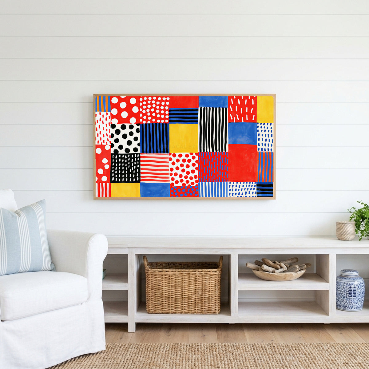 Polka dot patchwork Frame TV art above a white console with a rattan basket in a coastal living room