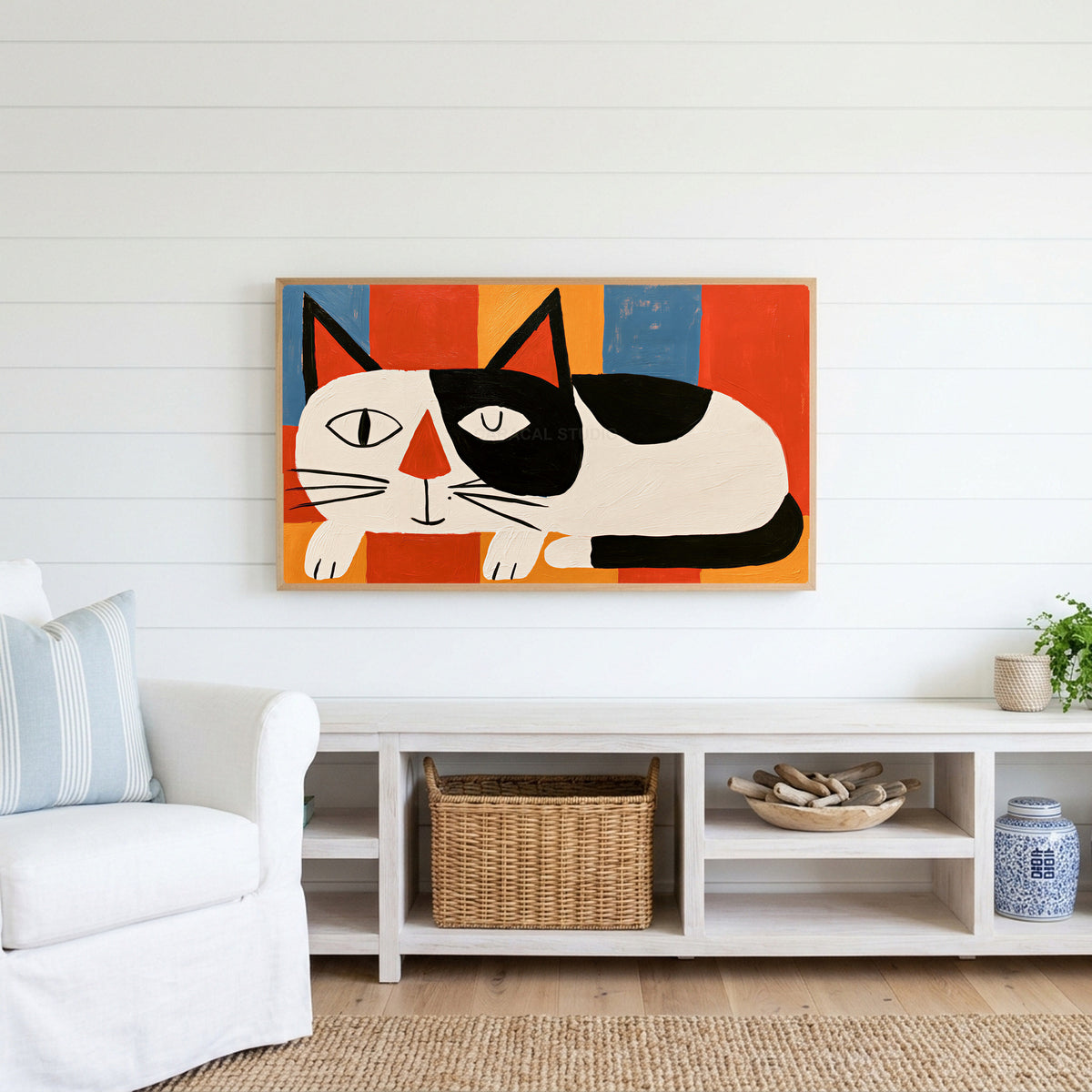 Winking black and white cat Frame TV art above a white console with a rattan basket in a coastal living room