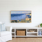 Low tide beach and cliffs Frame TV art above a white console with a rattan basket in a coastal living room