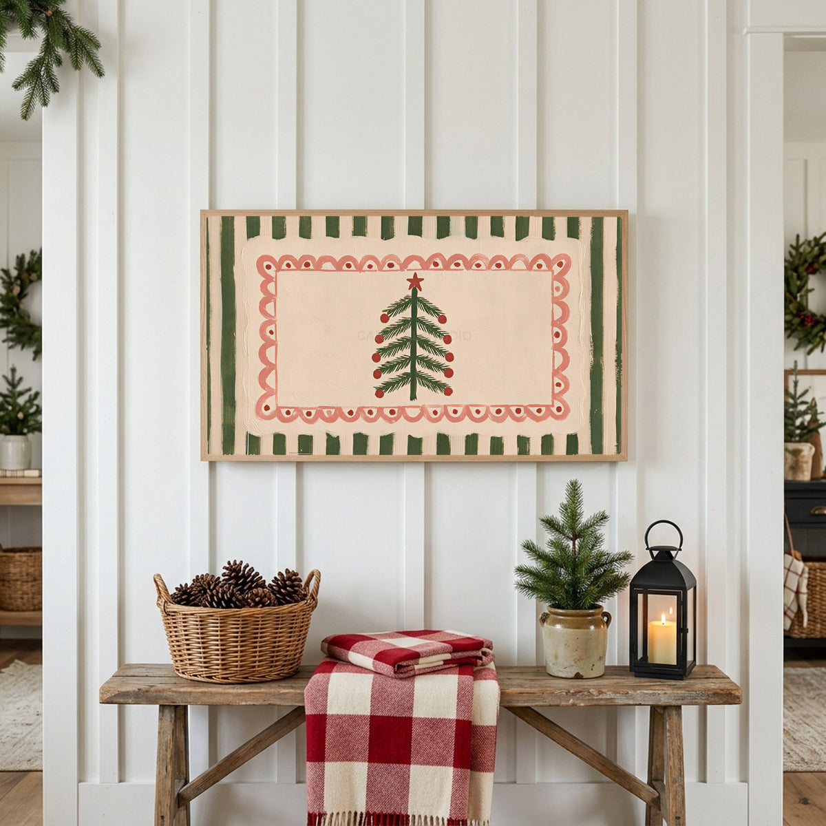 Folk Christmas tree Frame TV art above a rustic bench with pine cones and a red check blanket on a white plank wall